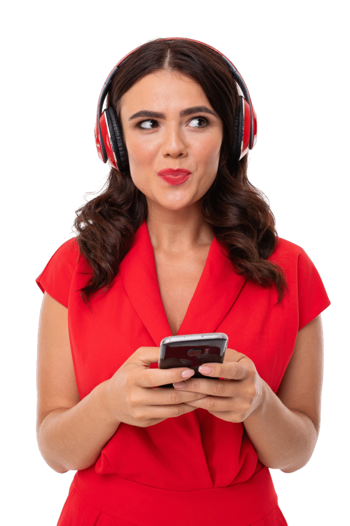 jeune femme aux levres rouges maquillage lumineux cheveux longs ondules sombres dans costume rouge lunettes noires verres transparents se tient ecoute musique dans ecouteurs tient telephone dans ses mains